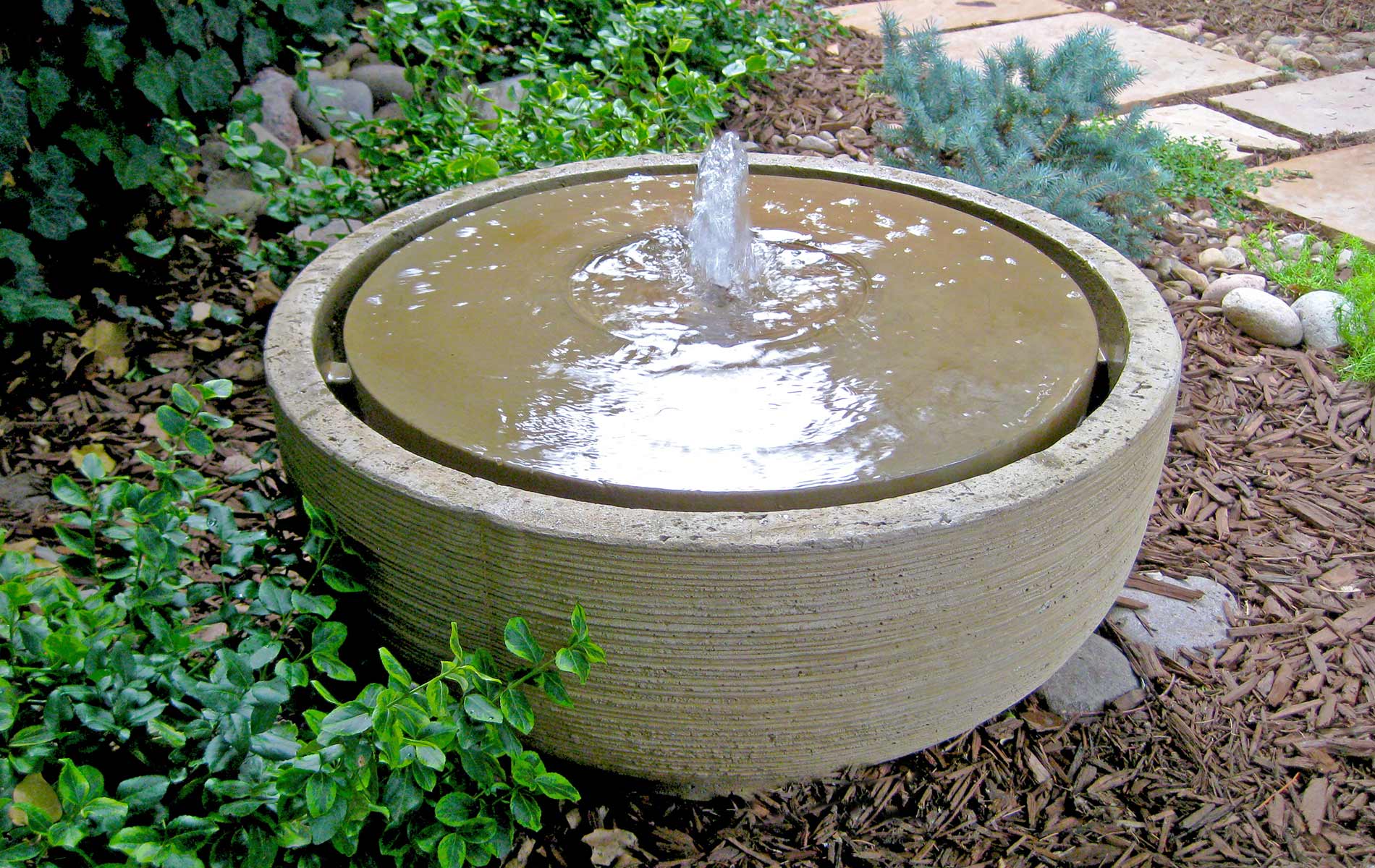 Cast stone water fountain in Custom Artwork Outdoor Room Featured in Sunset Magazine Mile High Landscaping in Denver