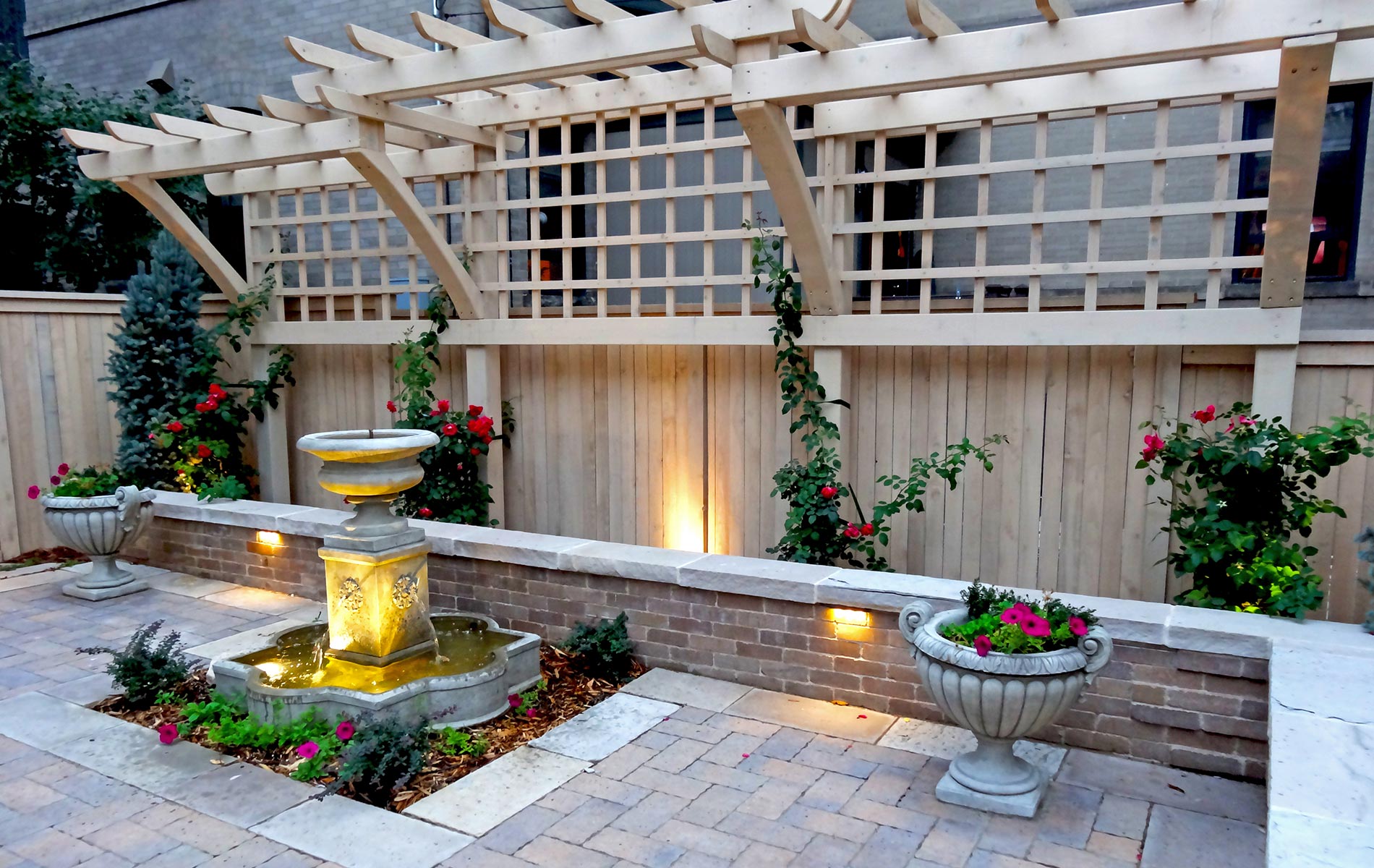 Ornate Wood Trellis, Brick Seat Wall, Paver Patio and Fountain in Historical House Courtyard Landscaped with Grand Architecture Mile High Landscaping in Denver