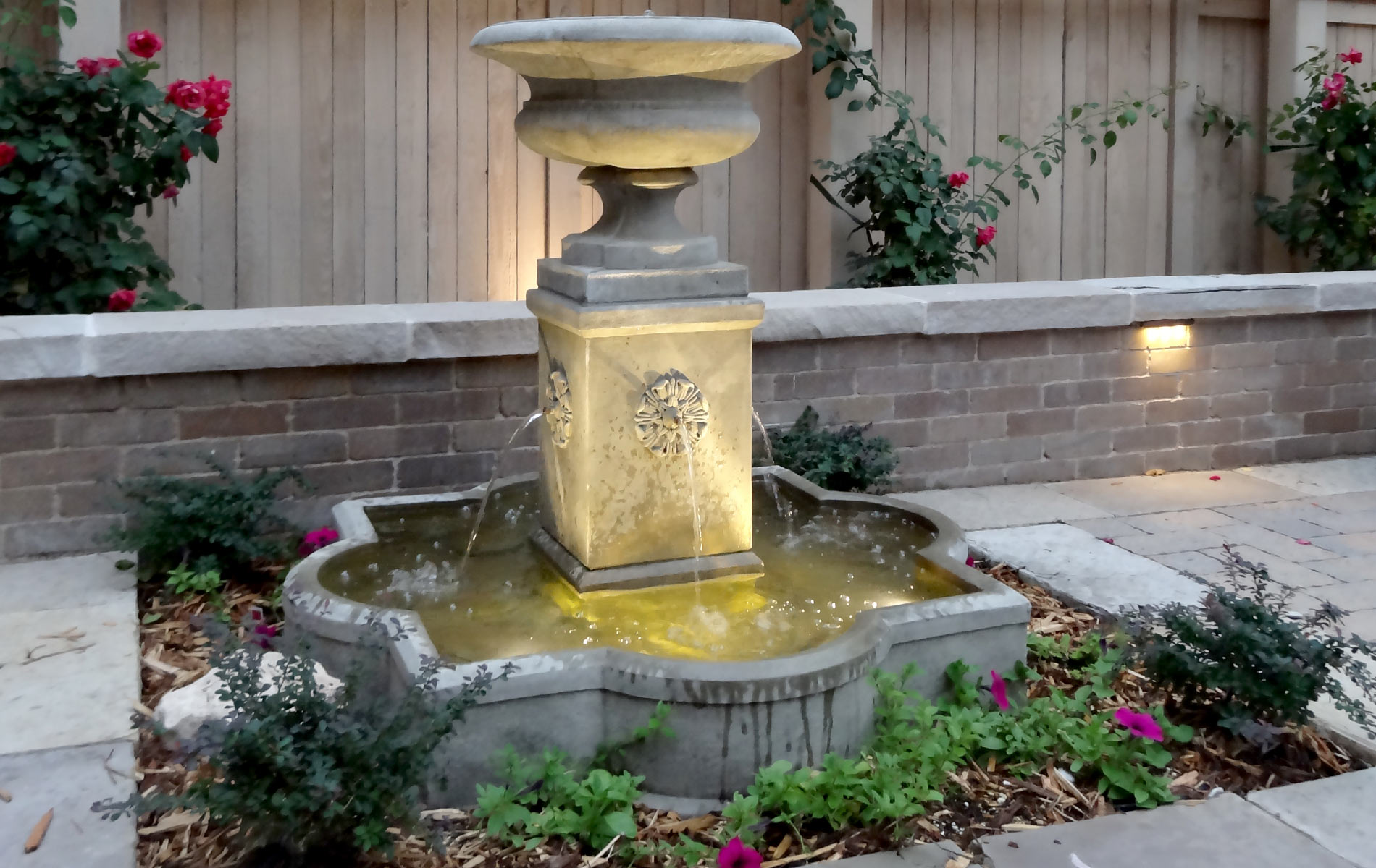 Cast stone water feature creates a soothing sound for formal outdoor living space