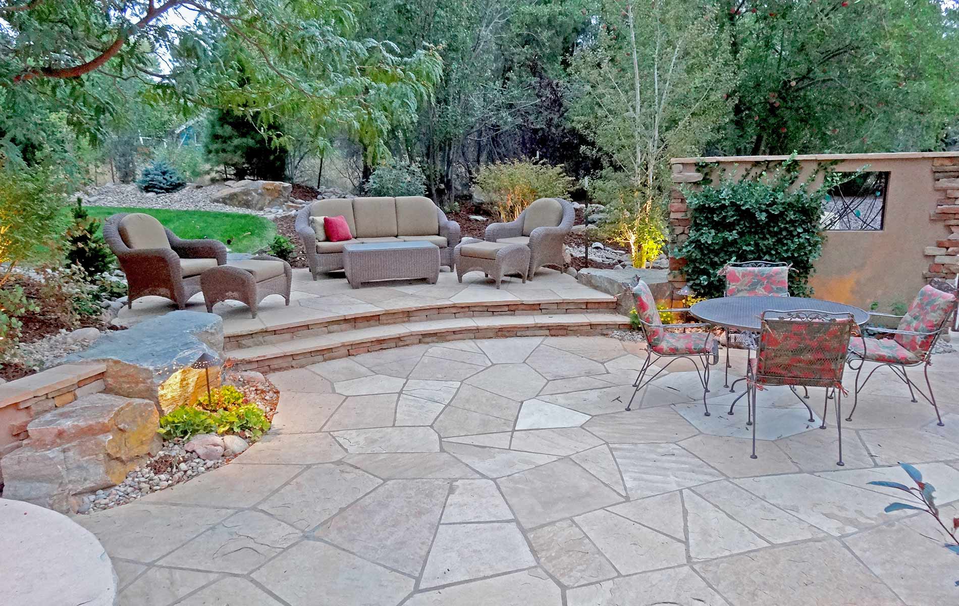 irregular arizona buff flagstone patio with strip stone stairs leading to upper outdoor living space